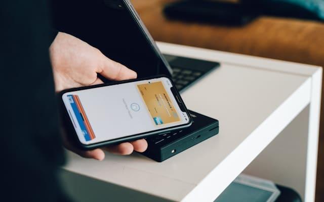 Une femme utilise son smartphone pour scanner sa demande afin de la faire valider.