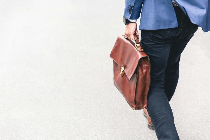 Un homme marche énergiquement avec sa sacoche.