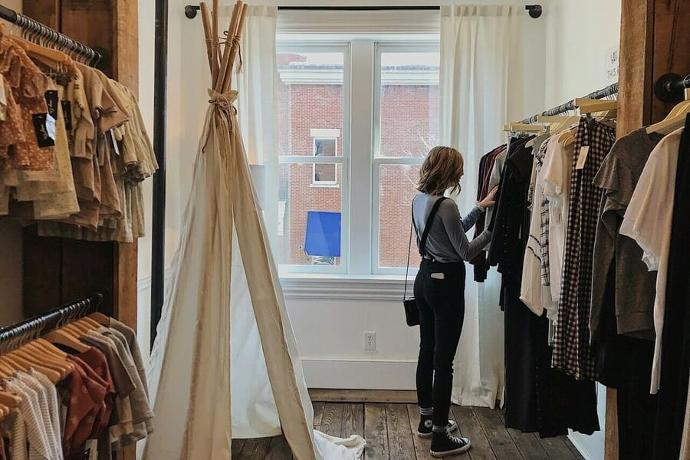 Une femme choisit des vêtements dans une boutique.