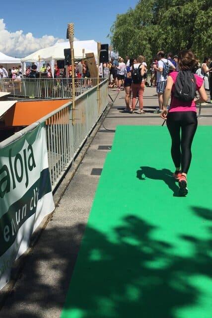 Une jeune femme de dos en tenue de sport participant à l'Ecotrail de Genève.