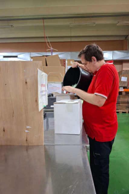 Un employé verse des chips de protection dans un colis
