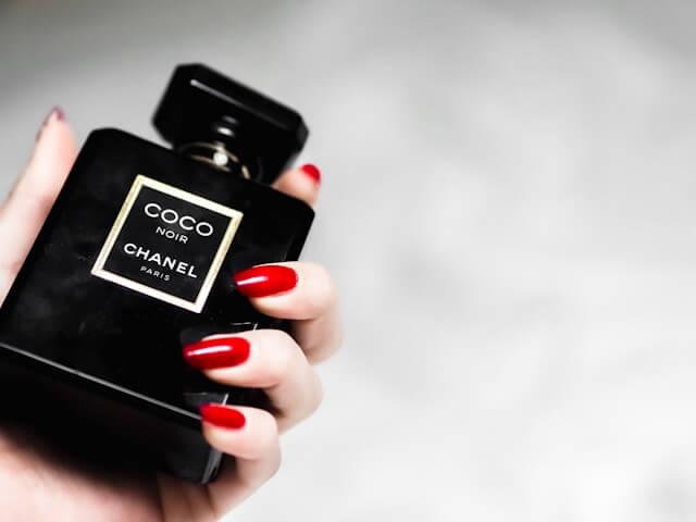 Une femme tient un parfum Coco Chanel dans sa main