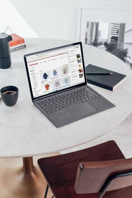 Un ordinateur posé sur une table affiche un site ecommerce.