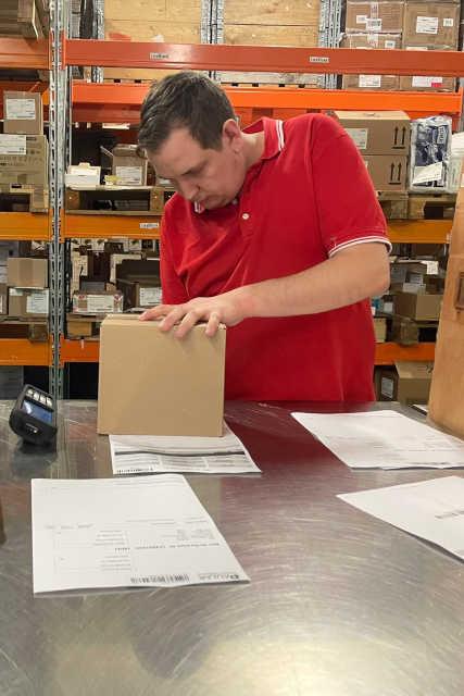 An employee finishes packing a product.