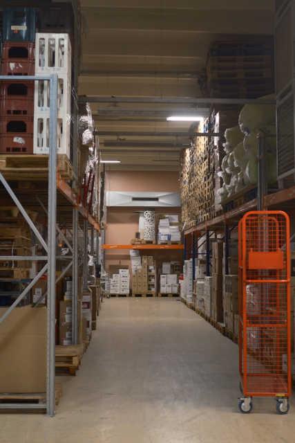 An aisle in the warehouse with merchandise on the shelves.