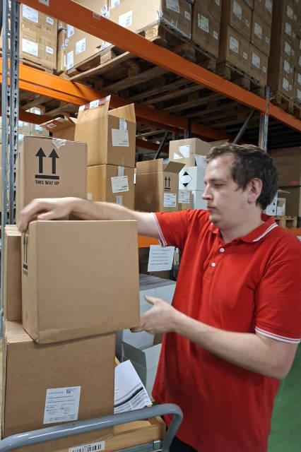 Un employé récupère les marchandises des commandes (picking).