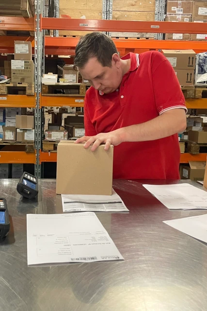 An employee finishes packing a product.